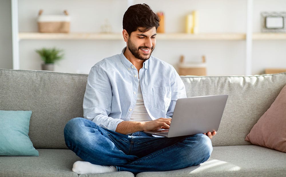 Man using a laptop on sofa