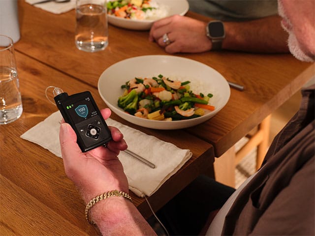 Main looking at MiniMed 780G pump during a meal