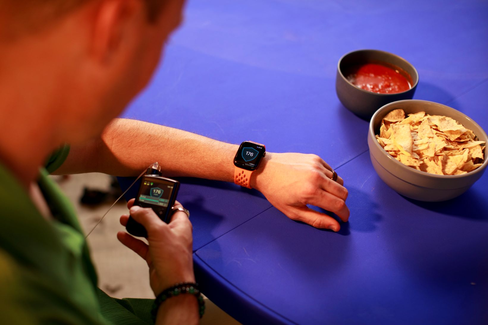 Person checking watch and insulin pump