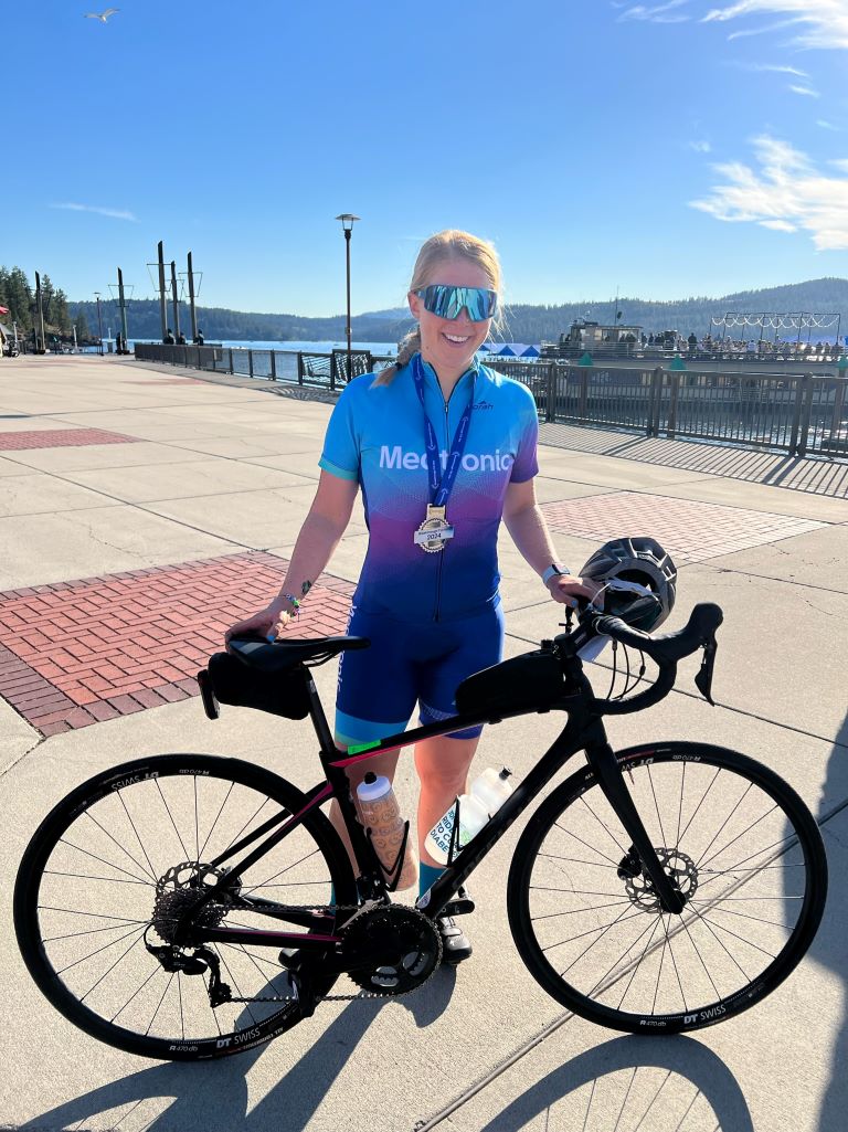 Medtronic Champion Heidi standing next to bike